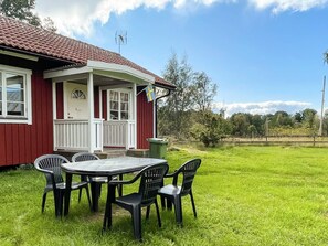 A red house with a porch and a table with chairs. - 4 Person Holiday Home in Morlunda (Mörlunda)