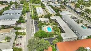 An aerial view of a hotel with multiple buildings, a swimming pool, and a parking lot. - Coastal Beach Retreat, Heated Pool, Walk to Beach, Water Taxi (Pompano Beach)