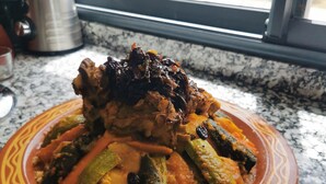 Un plat de menjar damunt d'una cuina, amb una finestra de fons.