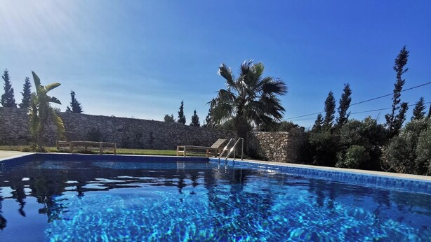 Trat de petit esmorzar al costat de la piscina, amb una tassa, suc i bol de cereals.