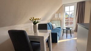 En modern lägenhet med ett matområde, en soffa och utsikt över omgivningarna.