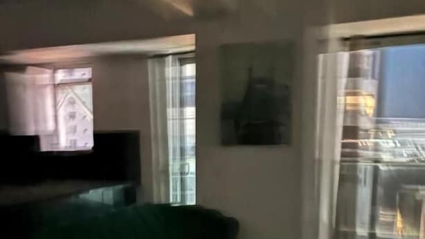 A living room with a green sofa, a small round table, and a TV. - Central Suites Tower T&T Rentals (Santo Domingo)