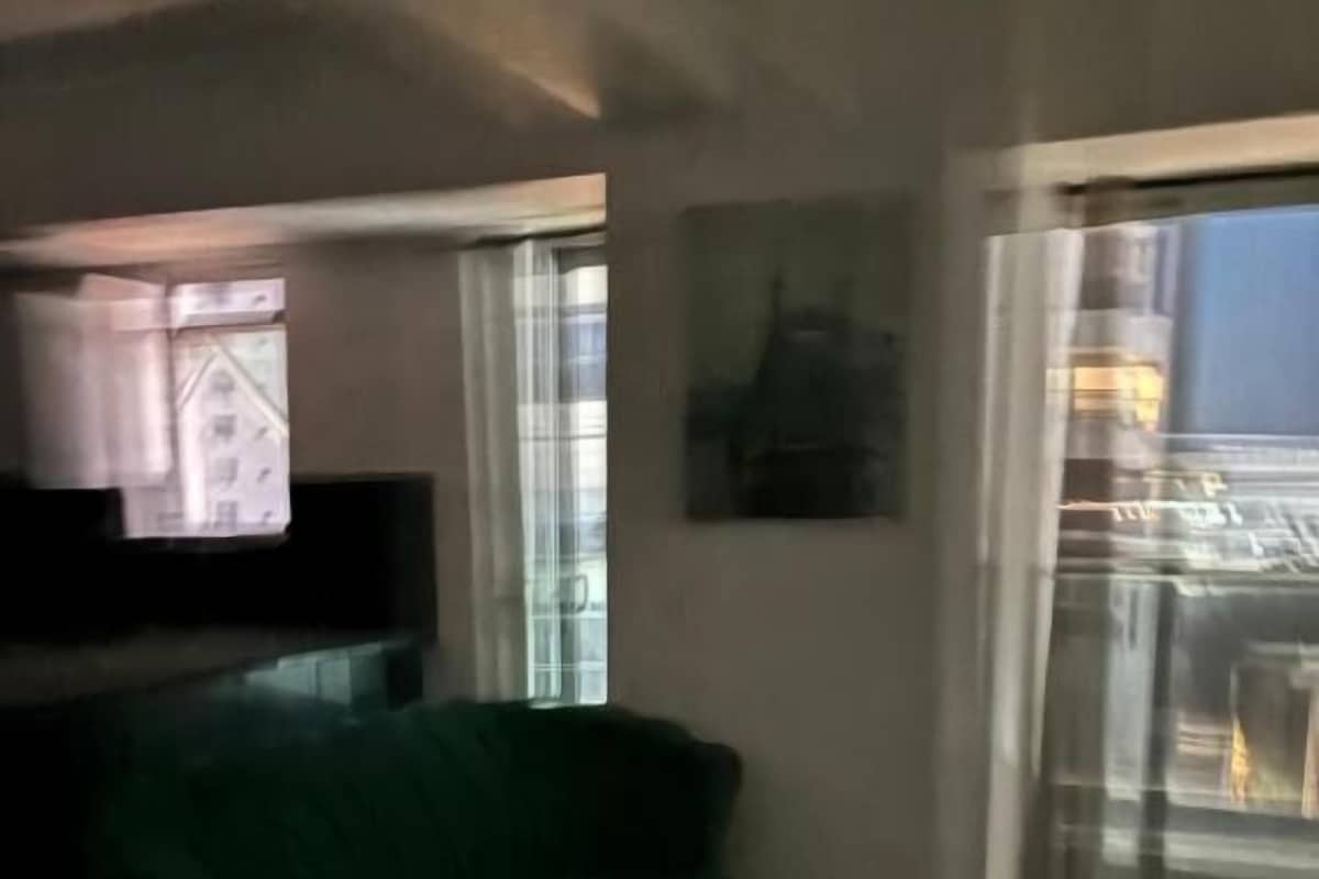 Ein Wohnzimmer mit einem grünen Sofa, einem kleinen runden Tisch und einem Fernseher.