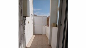 A narrow corridor with tiled flooring, a white door, and a window on the right. - Luxury & Fully Equipped | Safe & Terrace | All Amenities within Walking Distance (Tunis)