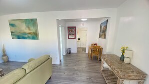Una sala de estar con un sofá, una mesa de madera y un cuadro en la pared.