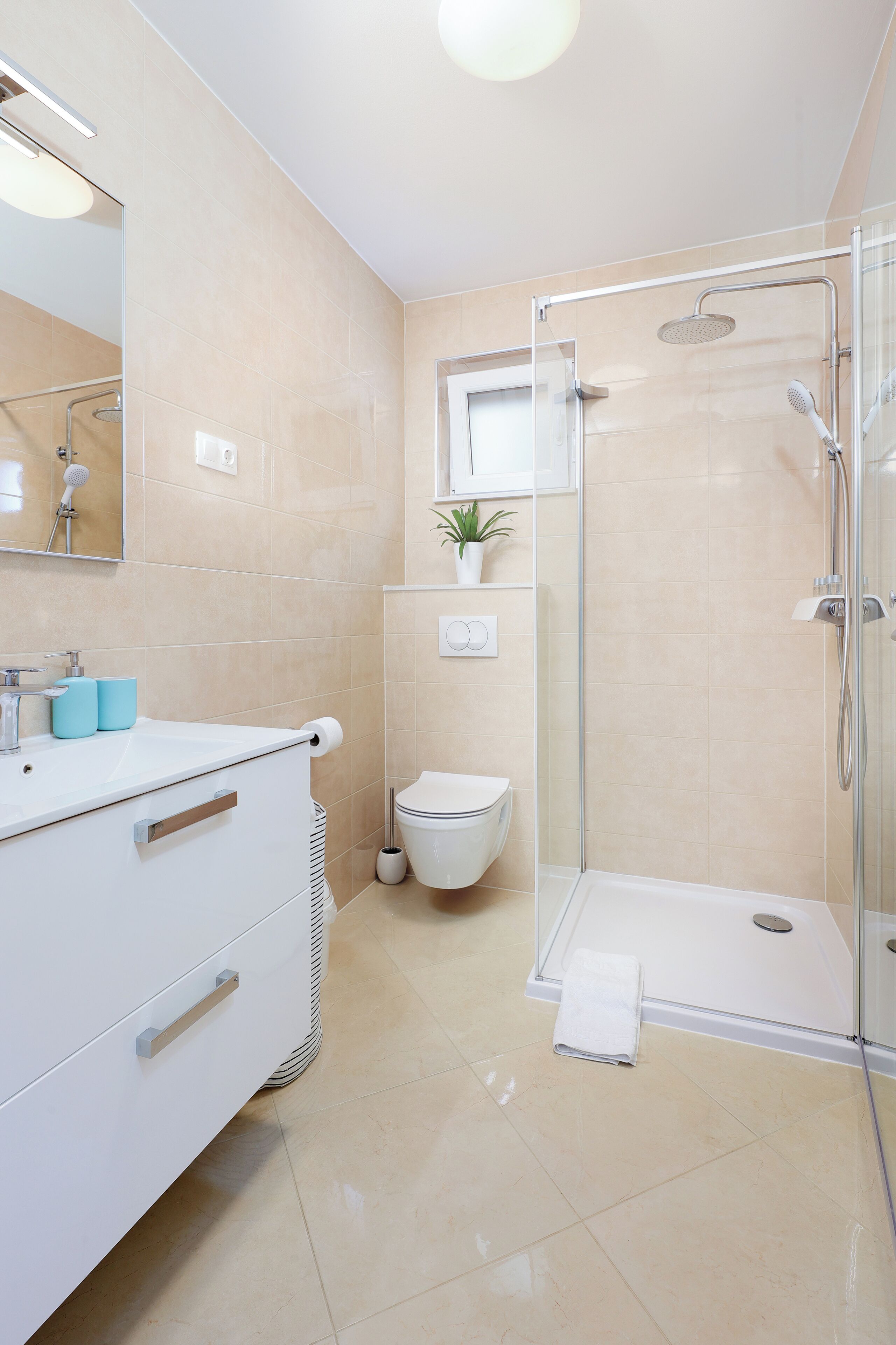 Un bagno moderno con doccia vetrata, un lavandino bianco con specchio e il water.
