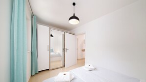 Una habitación de hotel con cama, baño, armario y espejo.