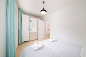 Ein Hotelzimmer mit Bett, Badezimmer, Kleiderschrank und Spiegel.