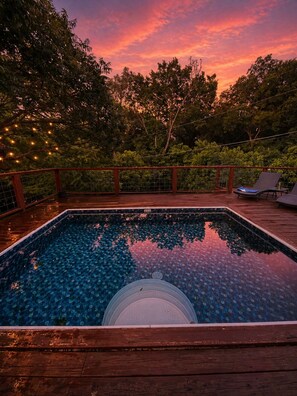 A swimming pool with a wooden deck, surrounded by trees and a sunset sky. - Pool Home-World Cup-10 Min AT&T Stadium-Sleeps 10 (Grand Prairie)