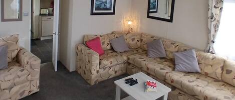 A living room with a sofa, a coffee table, and a lamp.