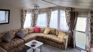 A living room with a sofa, a small table, and a ceiling fan.