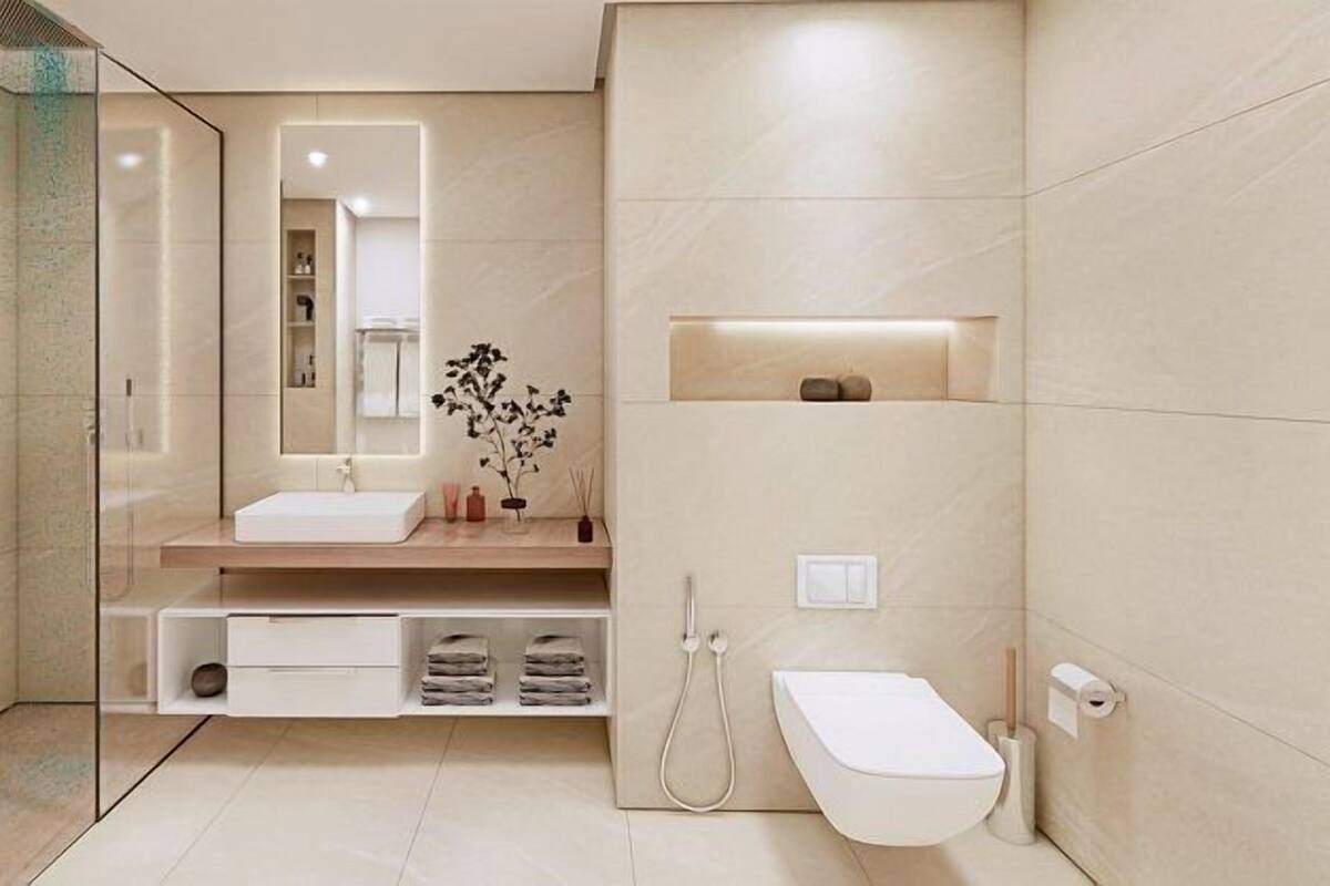 A modern bathroom with a glass shower enclosure, a white sink, and a toilet.