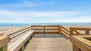A wooden boardwalk leading to a beach with a clear sky. - MB Five Seasons 6203- 1BR Close to Beach (Myrtle Beach)