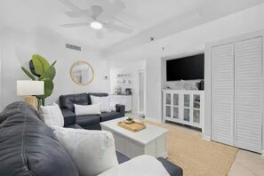 Ein modernes Wohnzimmer mit einer Couch, einem Couchtisch und einem Fernseher.