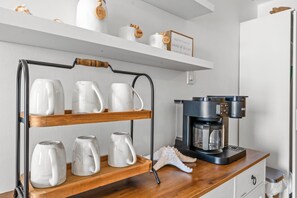 A kitchen with a coffee station featuring a shelf with cups and a Keurig coffee maker. - Oceanfront Buena Vista 703- 2BR- Outdoor Pool (North Myrtle Beach)