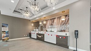 A reception area with a marble wall, a reception desk, a digital kiosk, and a chandelier. - Oceanfront Studio, Bay View Resort, 6th Floor, Indoor and Outdoor Pools, Balcony (Myrtle Beach)