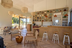 Un intérieur spacieux comprenant un bar, des espaces pour s’asseoir et une vue sur l’extérieur.
