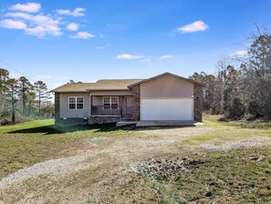 A single-story house with a garage, a front porch, and a driveway leading to the garage. - Sugar Hill Home ~ simple & quiet 3BR near town (Mountain View)