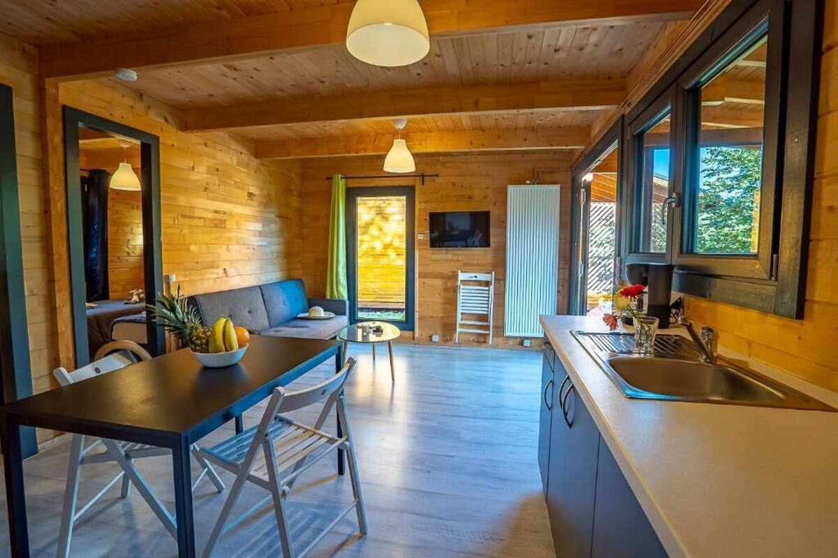Ein Holzhütten-Interieur mit Essbereich, Küche und Sitzgelegenheit.