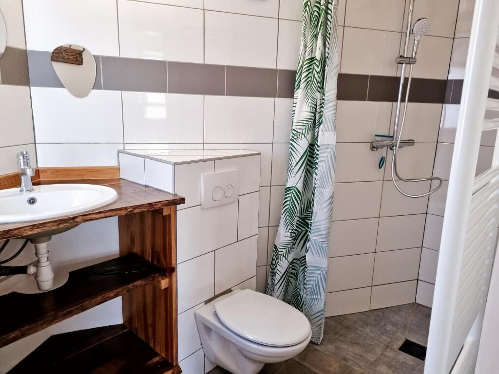 Une salle de bain équipée d’un lavabo, de toilettes, d’une douche et d’un porte-serviettes.