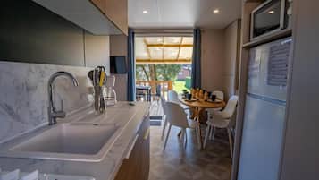 Una cocina moderna con un fregadero, estufa y comedor con sillas y una mesa.