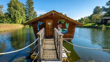 A wooden cabin with a dock, a sign, and a number 151.