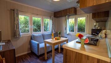 Una cocina funcional con comedor, armarios de madera y ventana con vista a follaje.