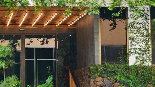 A hotel entrance with a sign reading 'HOTEL LA CLOIX,' a wooden staircase, and a stone wall. - Premium Kalākaua Haus Kitchenette (Honolulu)