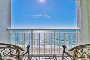 A balcony with a view of the ocean, a railing, and a chair. - 1BR Oceanfront Paradise @Camelot! (Myrtle Beach)