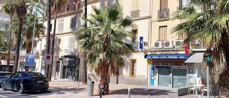 A street scene with a building that has a sign for a bar, tobacco, lottery, and PMU.
