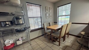 A kitchen with a dining table, chairs, and a window with blinds. - Family and Pet Friendly Home in Benton, AR (Benton)