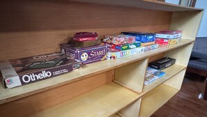 A wooden shelf with various board games and a box of Othello. - Family and Pet Friendly Home in Benton, AR (Benton)