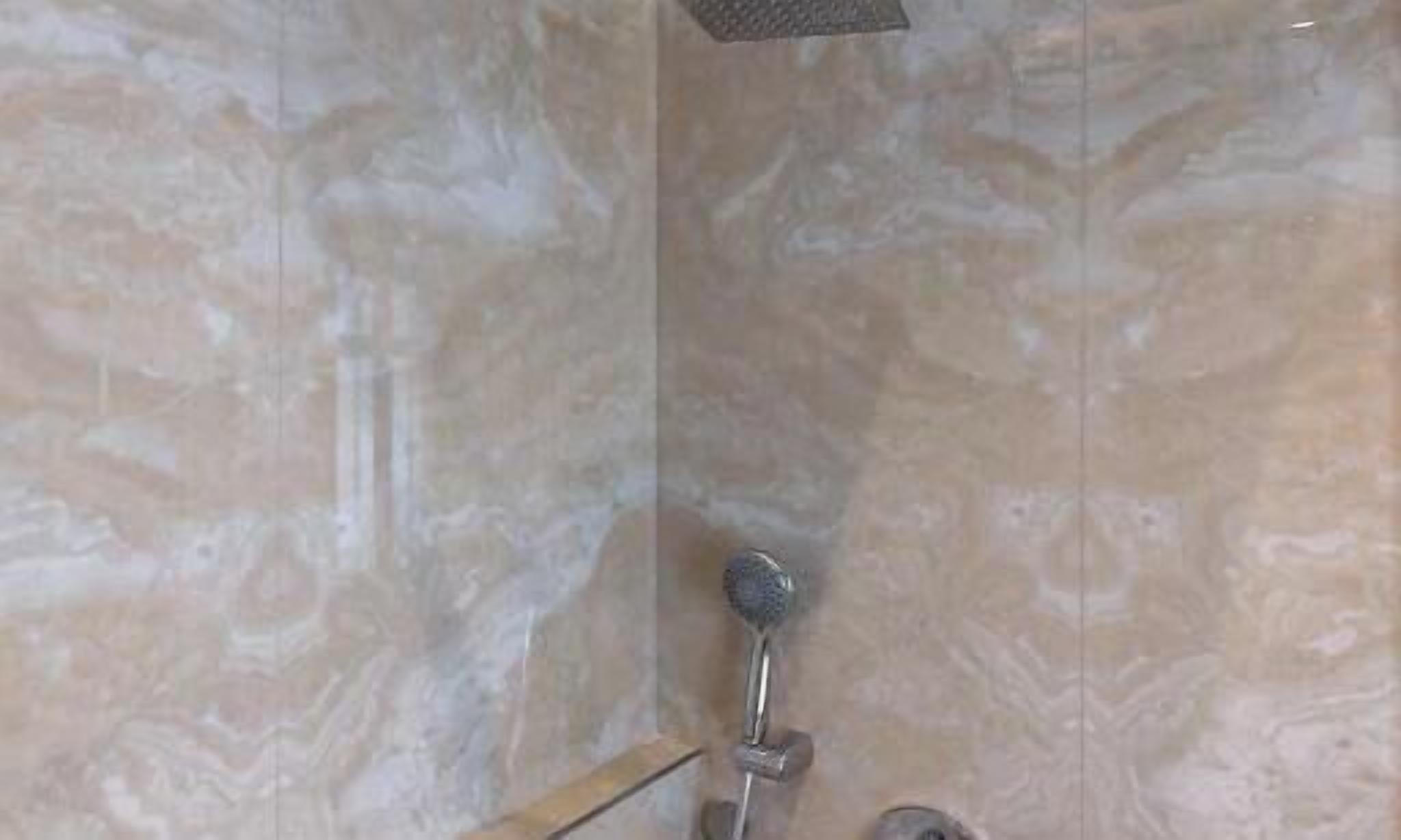 Ducha con cabezal de ducha de mano y grifería empotrada.