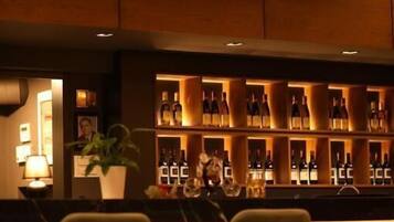 A bar area with seating and shelves of bottles.