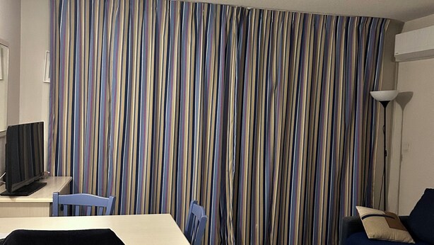 A room with a striped curtain, a desk with a computer, a chair, a sofa, and a lamp. - T2 Sanary near sea (Sanary-sur-Mer)