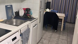 A compact kitchen with a washing machine, a microwave, and a refrigerator. - T2 Sanary near sea (Sanary-sur-Mer)