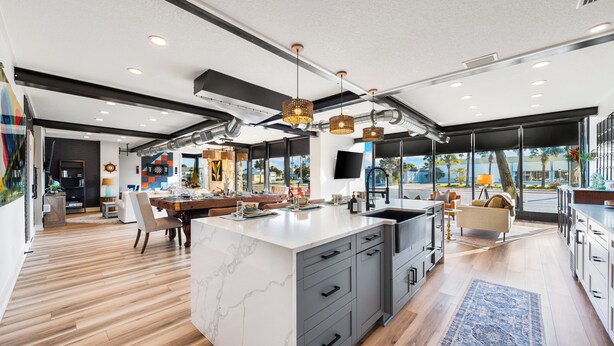 A modern kitchen with a marble island, grey cabinetry, and pendant lighting. - Sleeps 10 in Jax Beach - 2BR/2BA - Pool Table + Firepit (Jacksonville Beach)