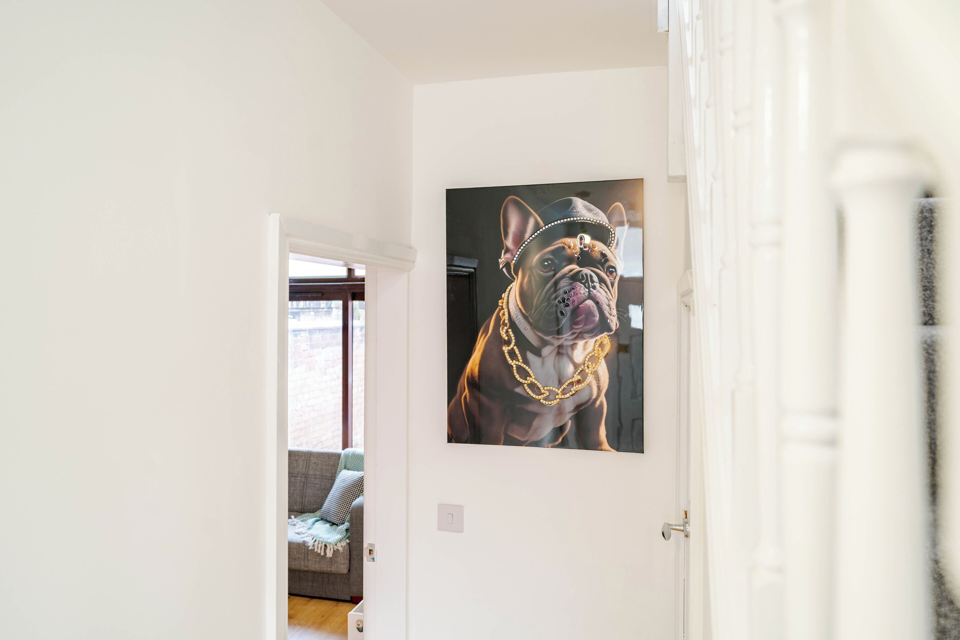 A hallway with a framed picture of a dog on the wall.