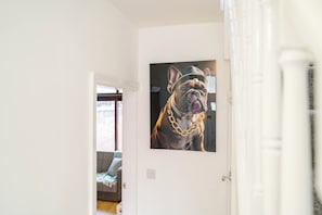 Een gang met een lijst waarop een foto van een hond staat.