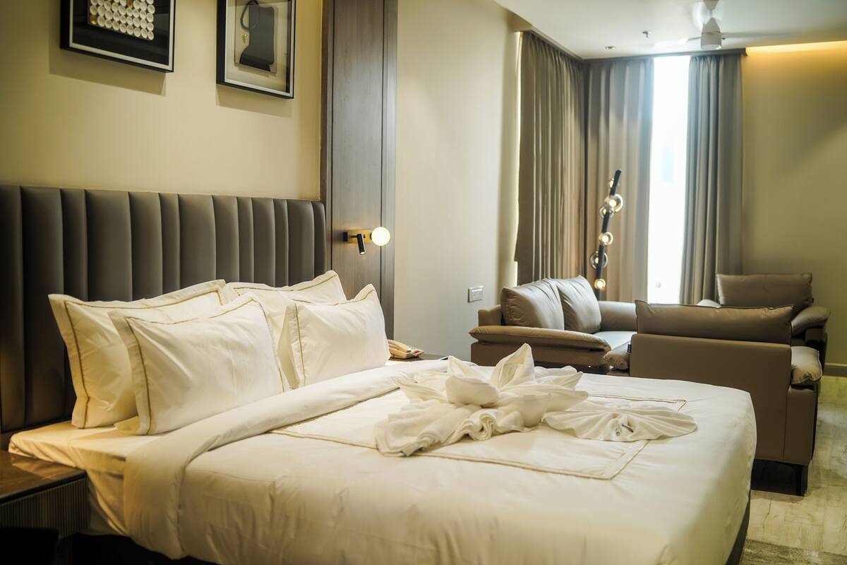 Habitación de hotel con una cama grande, un sofá, una silla y un escritorio.