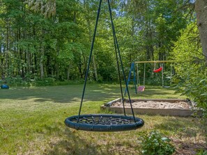 A swing set in a wooded area with a tire swing and a red hanging swing. - "Erk" -  from the sea by Interhome (Hadsund)