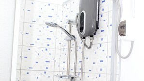 Eine Dusche mit Handbrause und am Wand montiertem Wasserhahn.