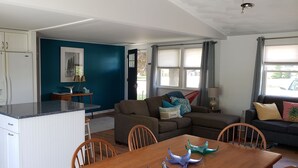 Un espace de vie compact comprenant une cuisine, un coin repas et un salon.
