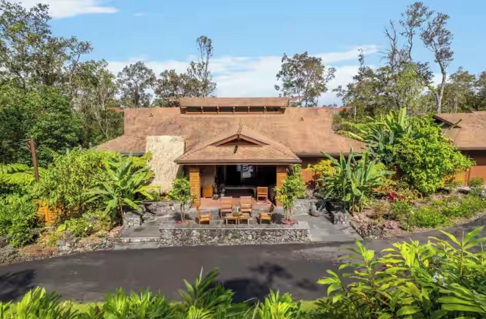 A building with a covered outdoor seating area, surrounded by lush greenery and a small pond. - Cloud 9, Hawaiian  Forest Retreat
Get away from it all, but close to everything. (Kailua-Kona)