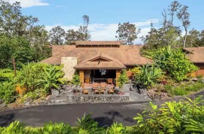 A building with a covered outdoor seating area, surrounded by lush greenery and a small pond. - Cloud 9, Hawaiian  Forest Retreat
Get away from it all, but close to everything. (Kailua-Kona)