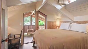 A bedroom with a bed, a chair, a window, and a door leading to an outdoor area. - Cloud 9, Hawaiian  Forest Retreat
Get away from it all, but close to everything. (Kailua-Kona)