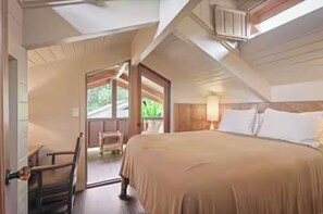 A bedroom with a bed, a chair, a window, and a door leading to an outdoor area. - Cloud 9, Hawaiian  Forest Retreat
Get away from it all, but close to everything. (Kailua-Kona)