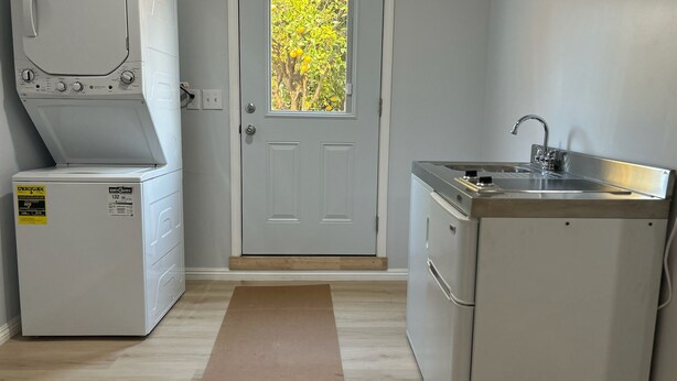 A compact kitchen with a washing machine, a sink, and a door leading to a garden. - Secret garden in center of LA, 3mi Sofi, 4 mi LAX, 6 mi beach, pets welcome (Los Angeles)