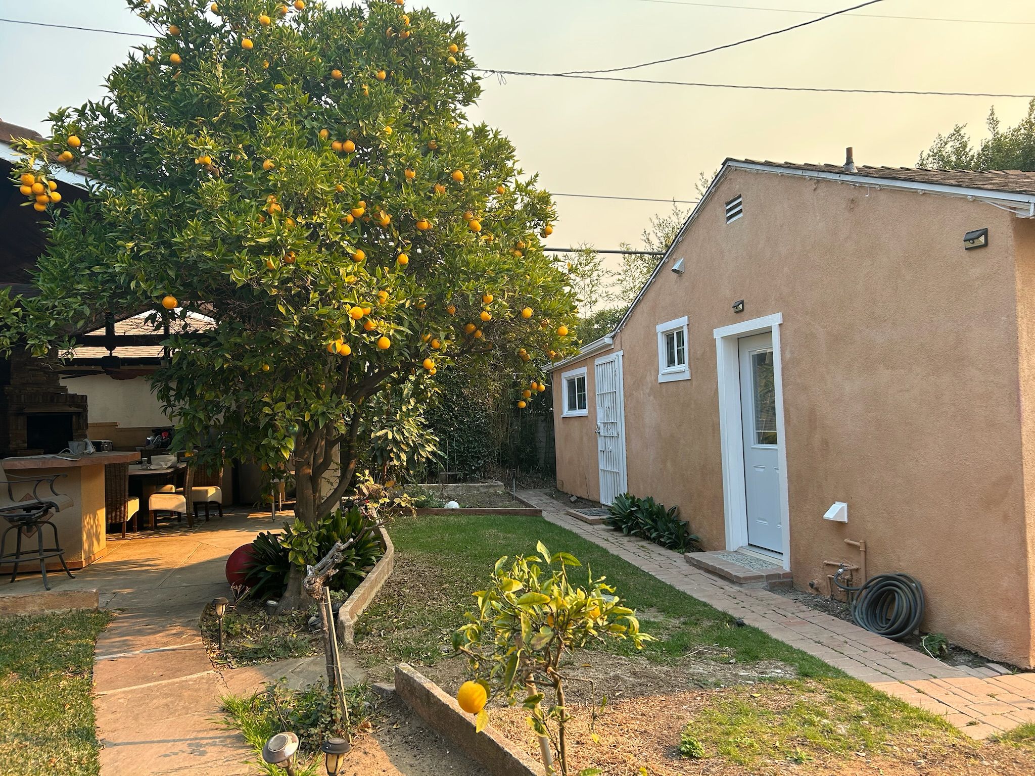 Una propiedad residencial con jardín, patio y una pequeña zona de estar al aire libre.