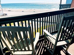 Ein Balkon mit Blick auf Strand und Meer.